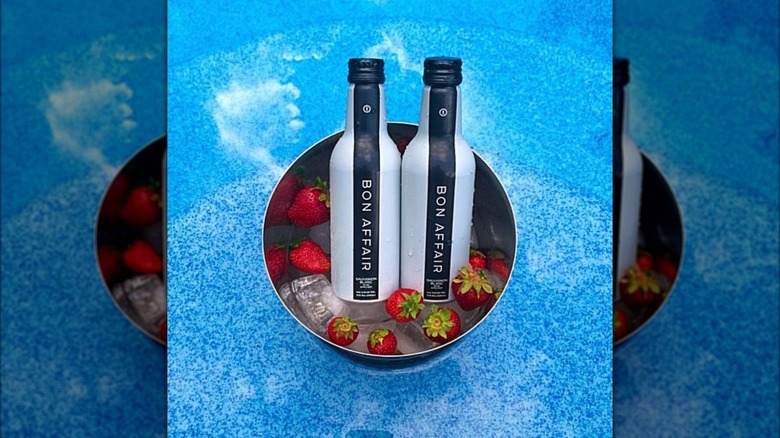 Two bottles of Bon Affair in an ice bucket with strawberriess