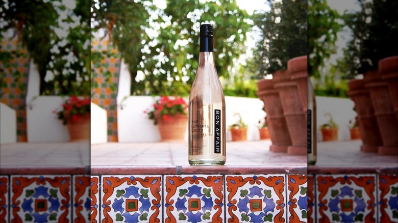 A bottle of Bon Affair on pool ledge