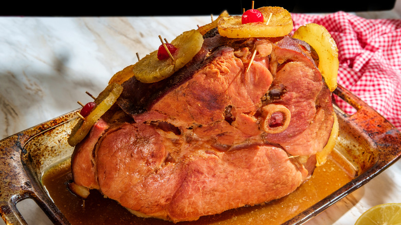 Bone-in ham with pineapple slices and cherries.