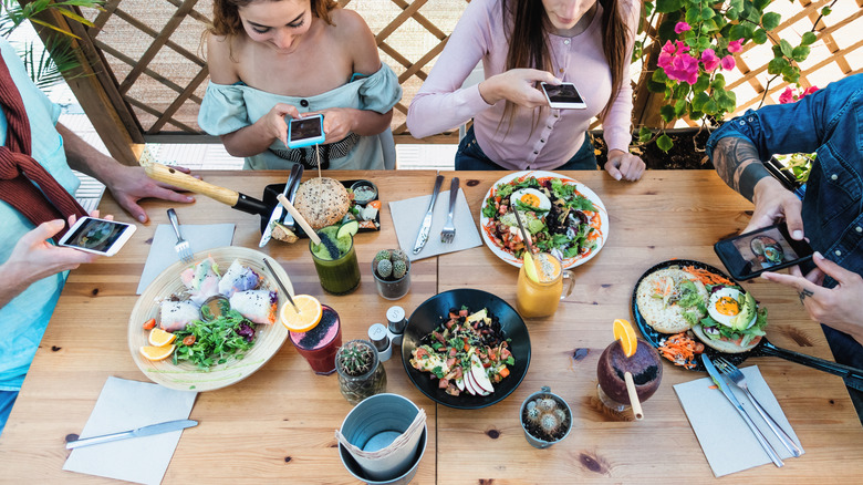 People taking pictures of their food at a restaurant