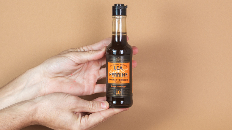 Hands holding bottle of Worcestershire sauce