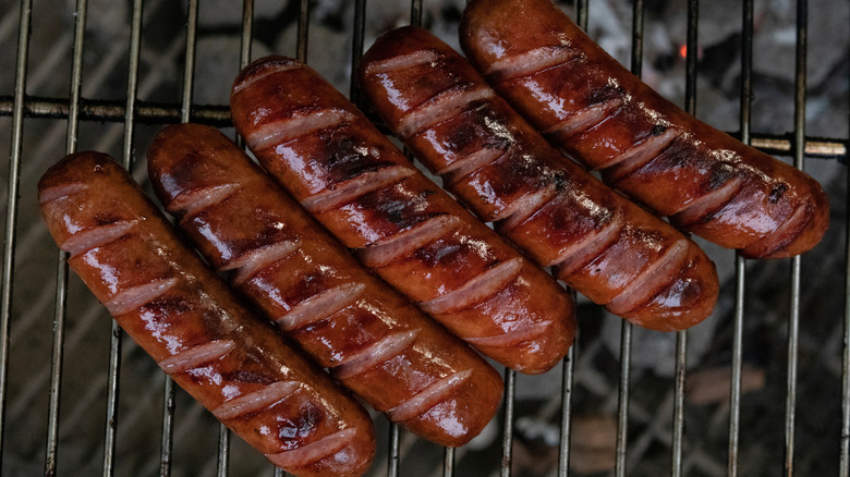 Knockwurst sausages on a grill.