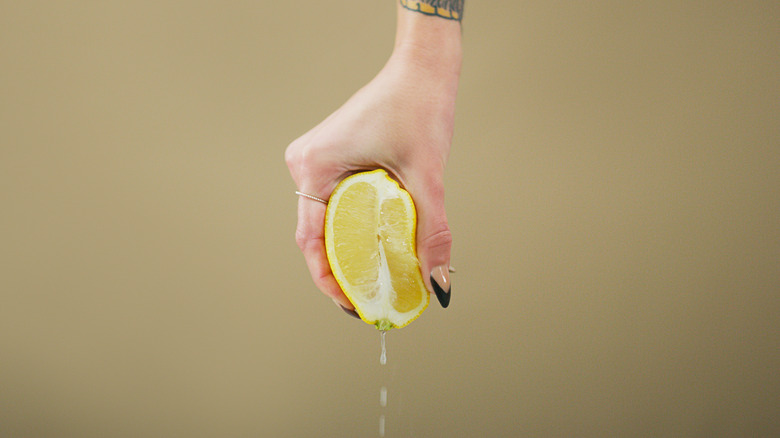 hand squeezing lemon