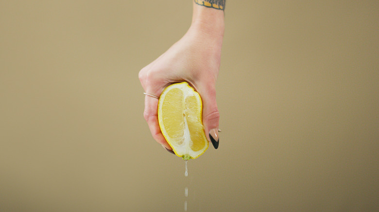 hand squeezing lemon