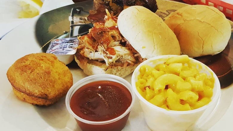 A BBQ platter from Bubba's Q, with a cup of mac and cheese, cornbread, and a pulled pork sandwich