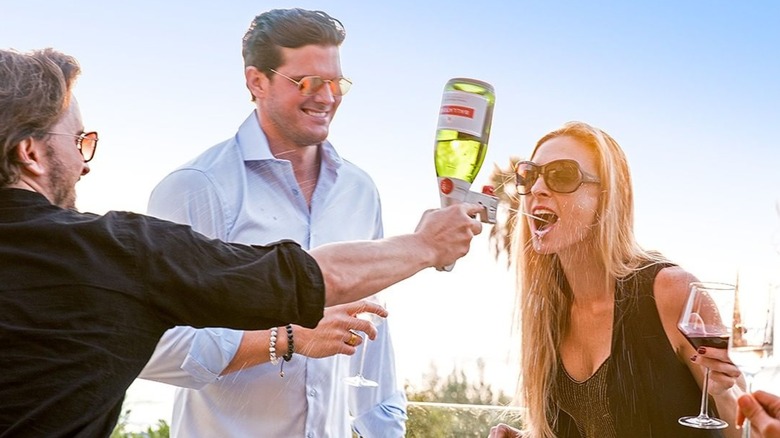Person spraying champagne is another person's mouth