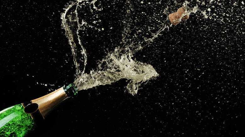 A bottle of champagne being sprayed