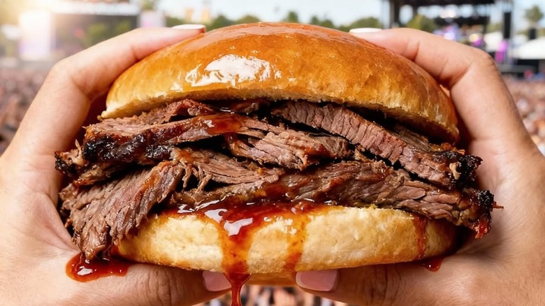 Two hands hold onto a brisket sandwich from Wally's.