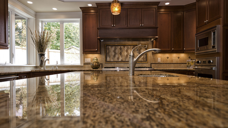 An island with a granite countertop in a high-end kitchen design.
