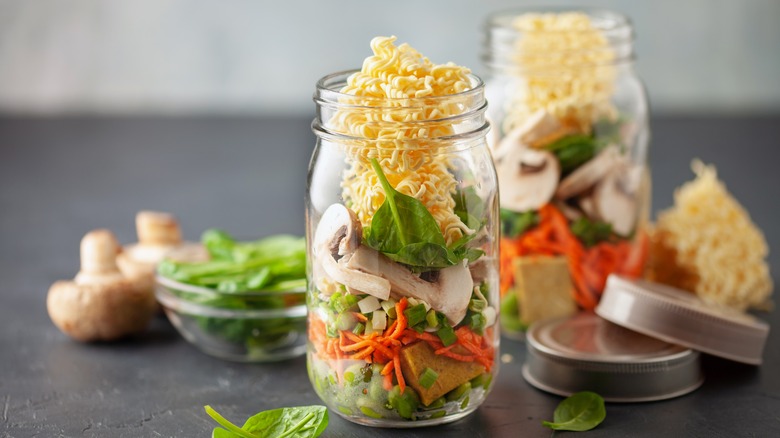 Instant ramen noodles and vegetables in glass mason jars