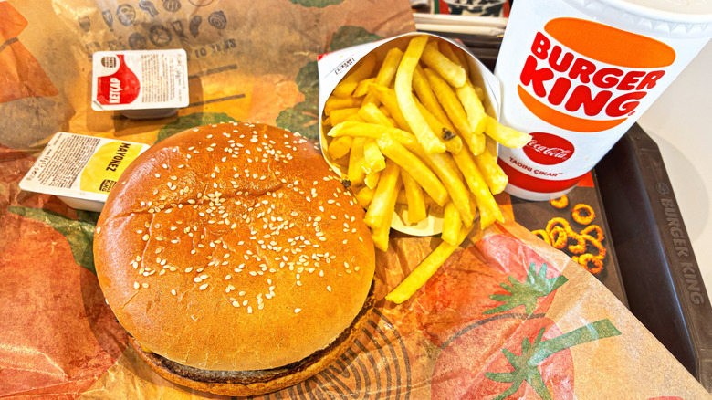 A Burger King burger, french fries, and a drink sit on a restaurant tray.