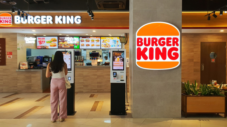 A woman ordering at a Burger King kiosk