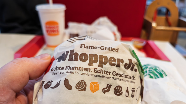 Person holding wrapped Whopper Jr.