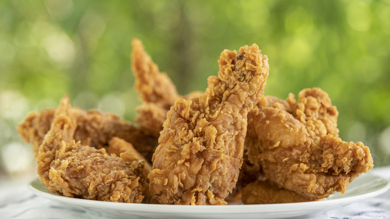 Fried chicken pieces on a white plate.