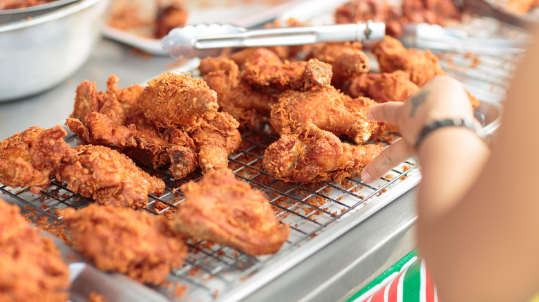 Fried chicken on a wire rack on a rimmed baking sheet.