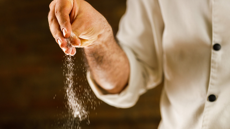 chef sprinkling salt