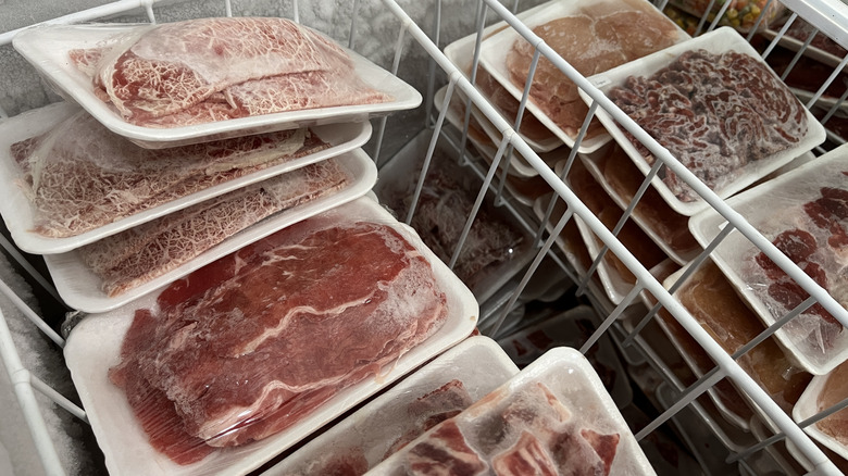 A chest freezer is full of different kinds of beef.