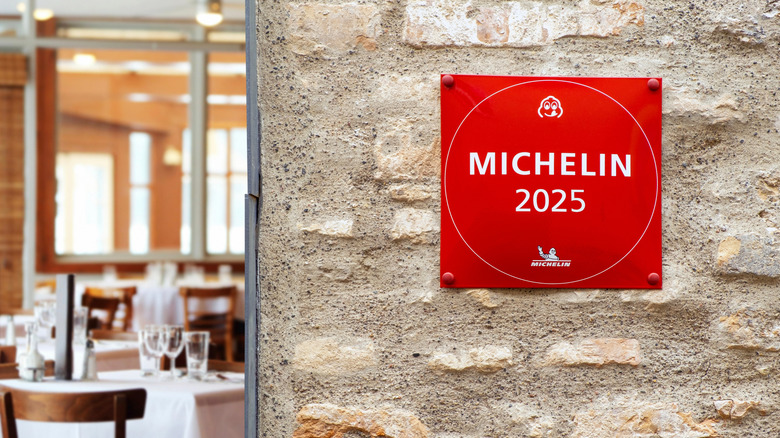 A Michelin star sign on a brick wall.