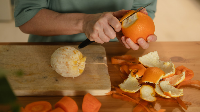 A homeowner peels oranges at a kitchen table