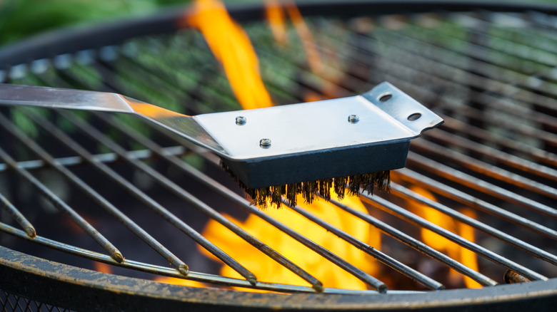 A scrub brush on a flaming grill.