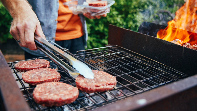Beef burger patties cooking on a hot grill