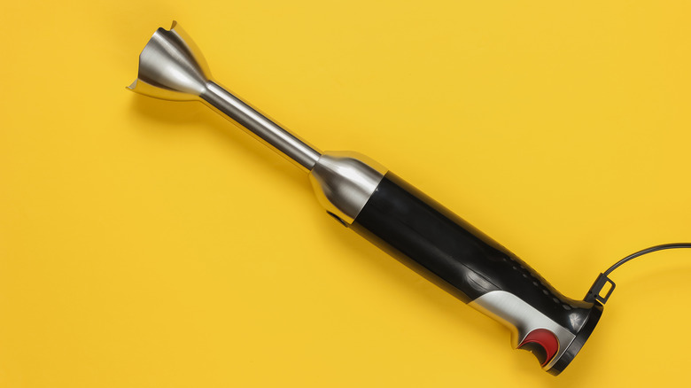Immersion blender on yellow background