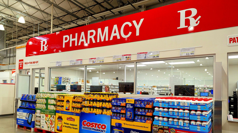 Bottles of vitamins and supplements sit in front of a Costco pharmacy