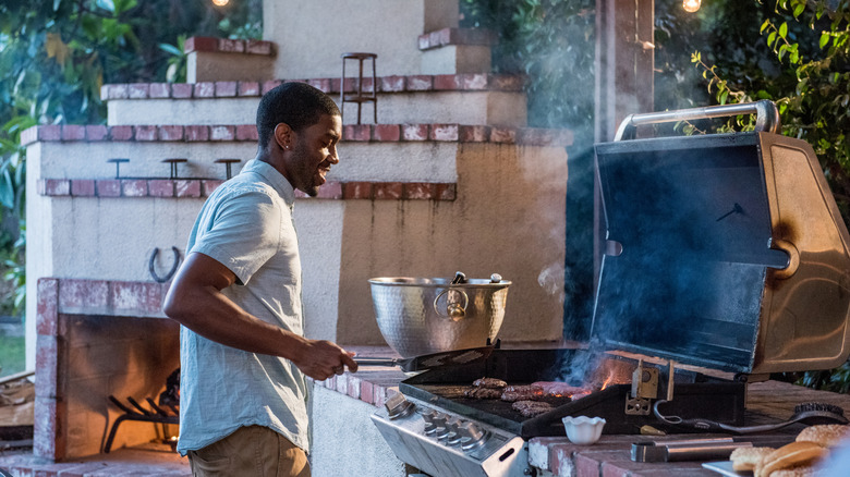 Man grilling under a covered porch
