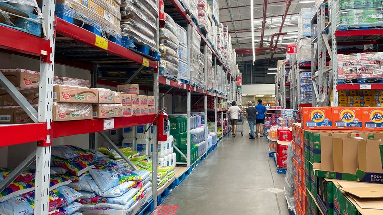At the other end of a Sam's Club aisle, three people shop