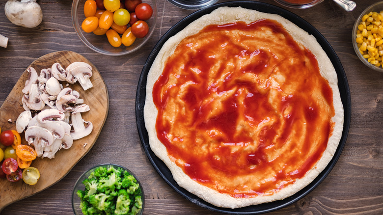 pizza sauce on uncooked dough