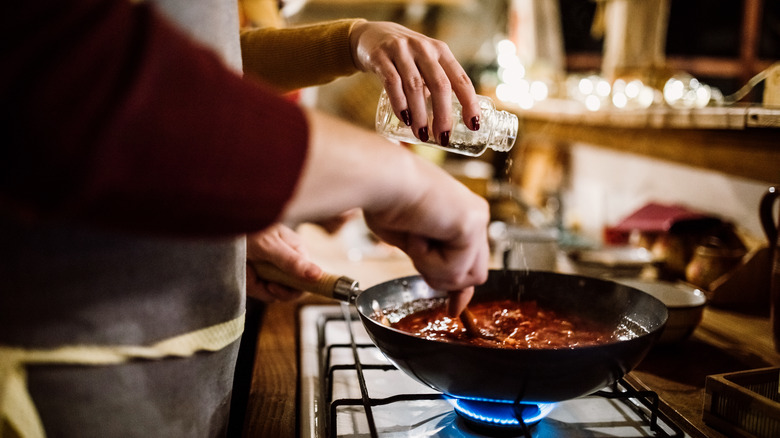 people simmering tomato sauce together