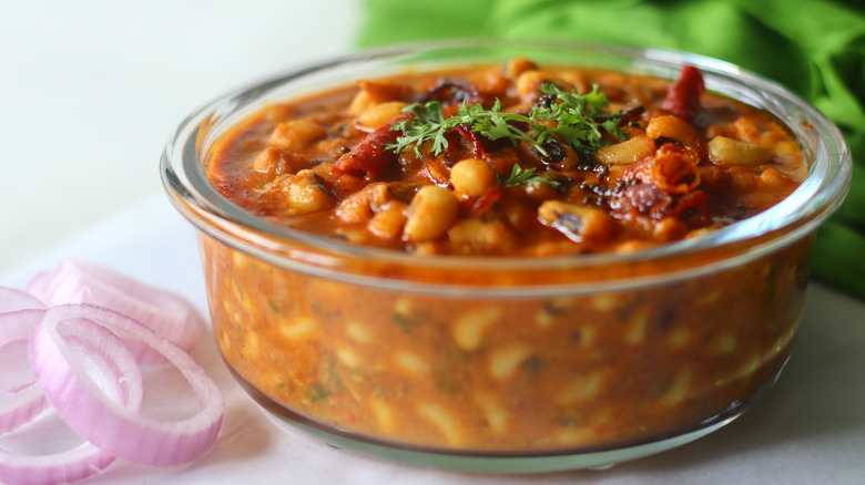 Baked beans sit in a glass dish.