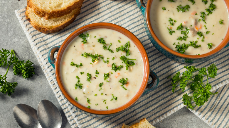 Clam chowder sits in two bowls on a table.