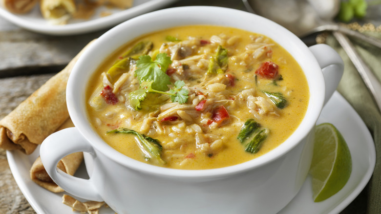 Chicken soup made with coconut milk in a white bowl