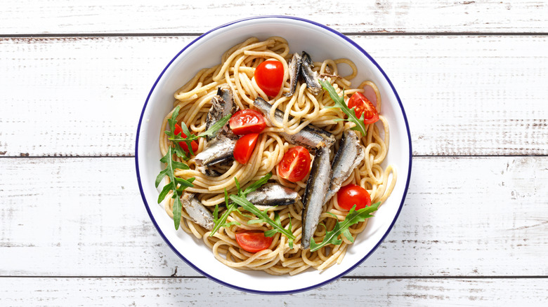 Sardines on pasta with tomatoes and arugula