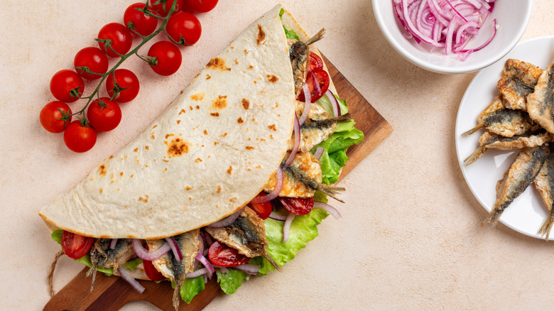 Wrap with sardines, tomatoes, red onions, and lettuce