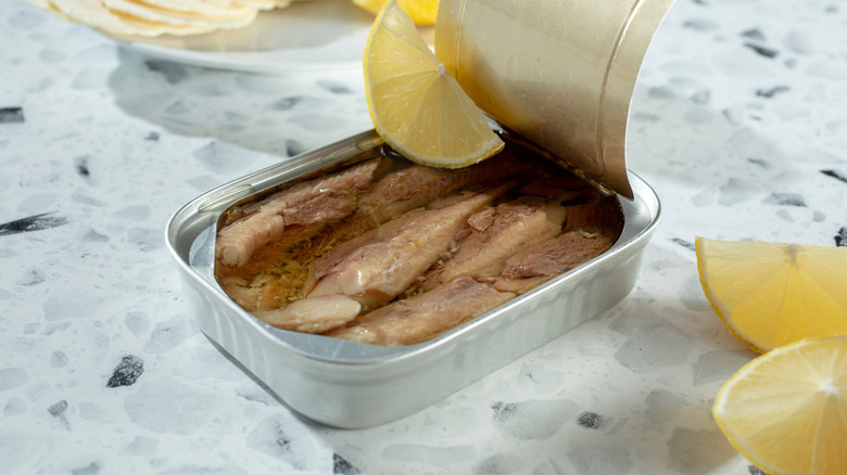 Open can of sardines with sliced lemon