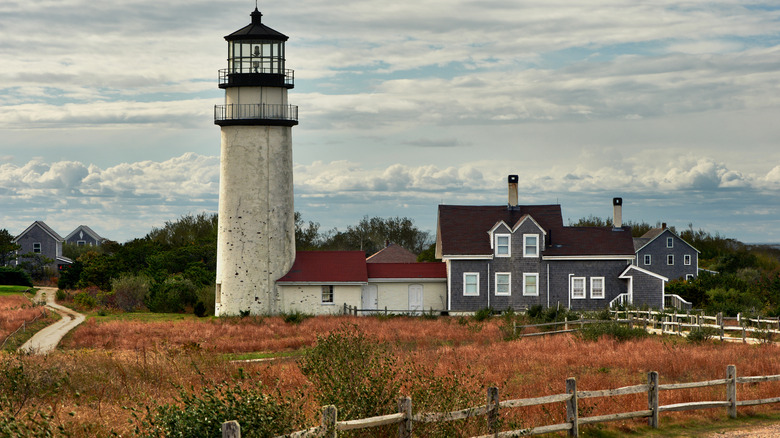 Lighthouse next to grey-shingled house on Cape Cod