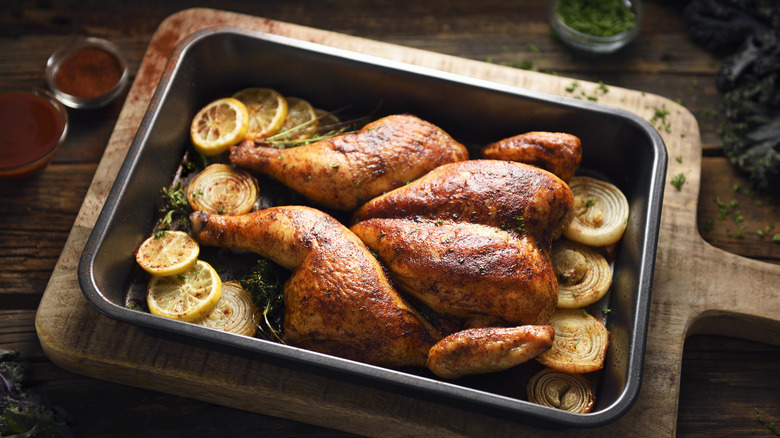 Roasted chicken with lemons in pan 