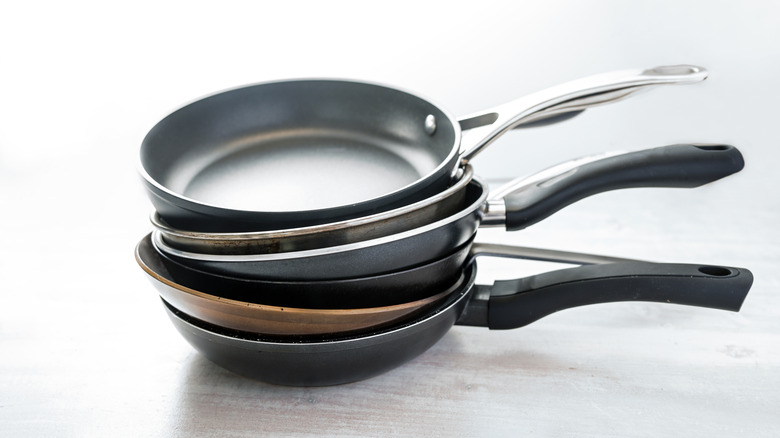 A stack of various types of frying pans.