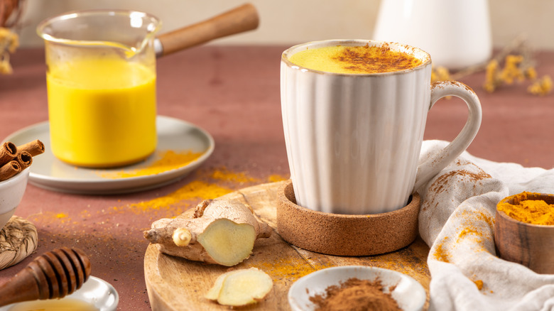 A golden milk latte surrounded by spices