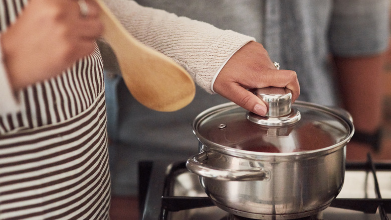 Cook holding glass lid