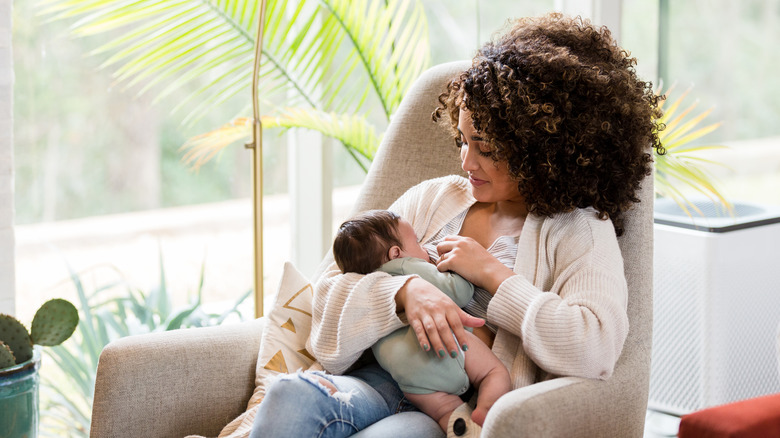 woman nurses newborn baby