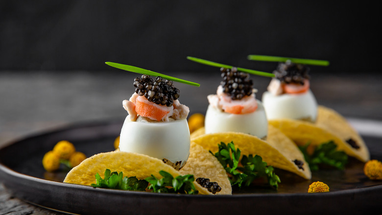 Caviar on quail egg and crab on potato chip