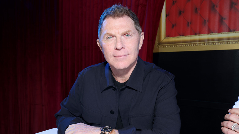 Bobby Flay in front of deep red curtain
