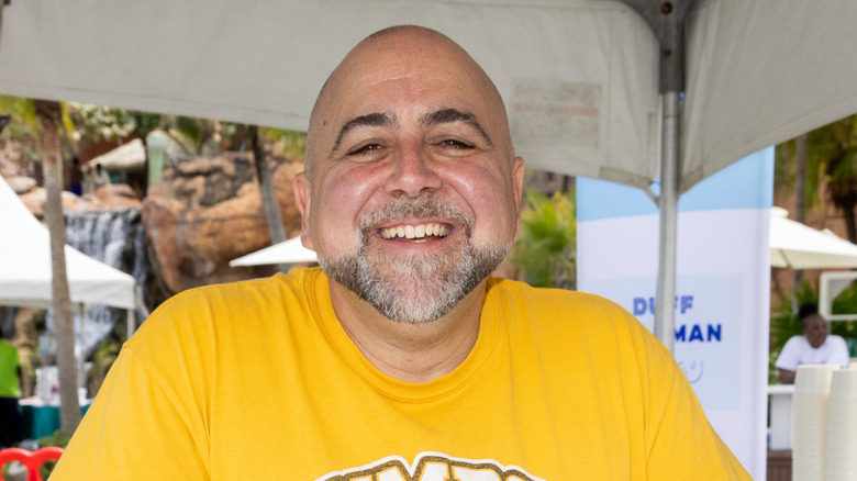 Duff Goldman in yellow t-shirt under outdoor tent