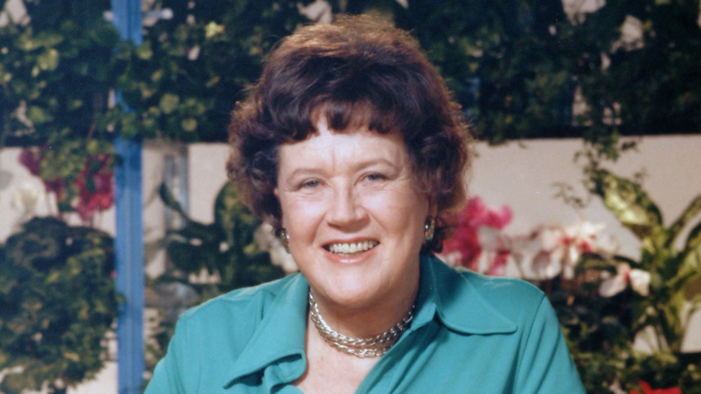 Julia Child posed in front of outdoor garden
