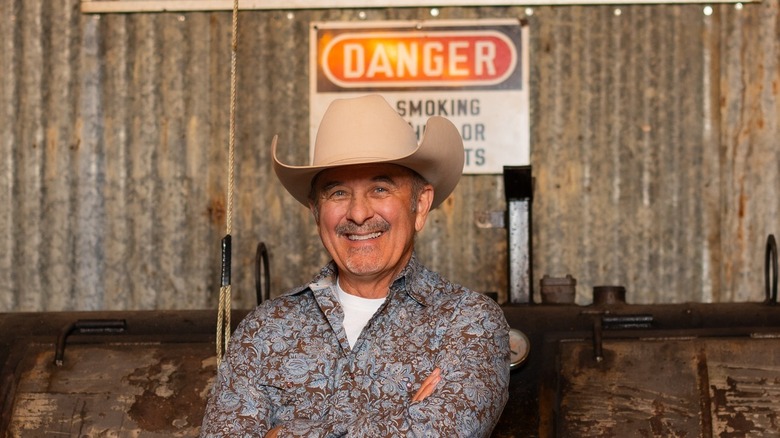 Robbie Shoults smiling in front of pit smoker