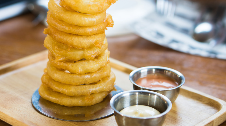 Onion ring tower with dipping sauces on a platter