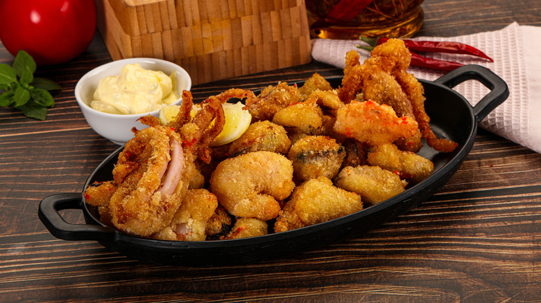 Platter of various fried seafood including shrimp, prawn, and mussels.